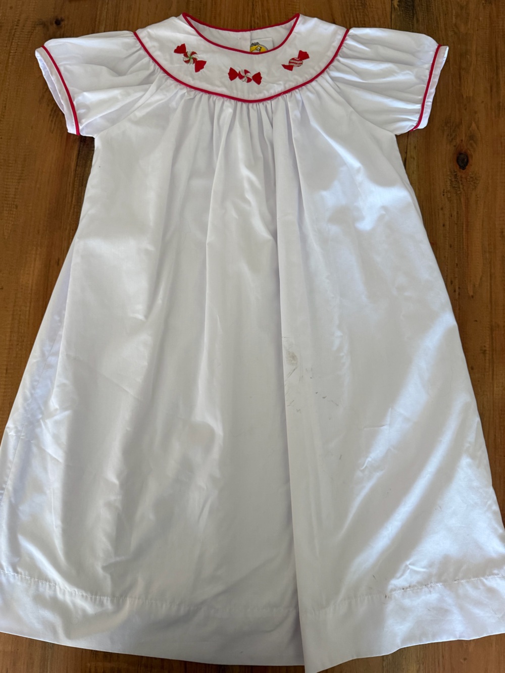 White holiday dress with red candy on collar
